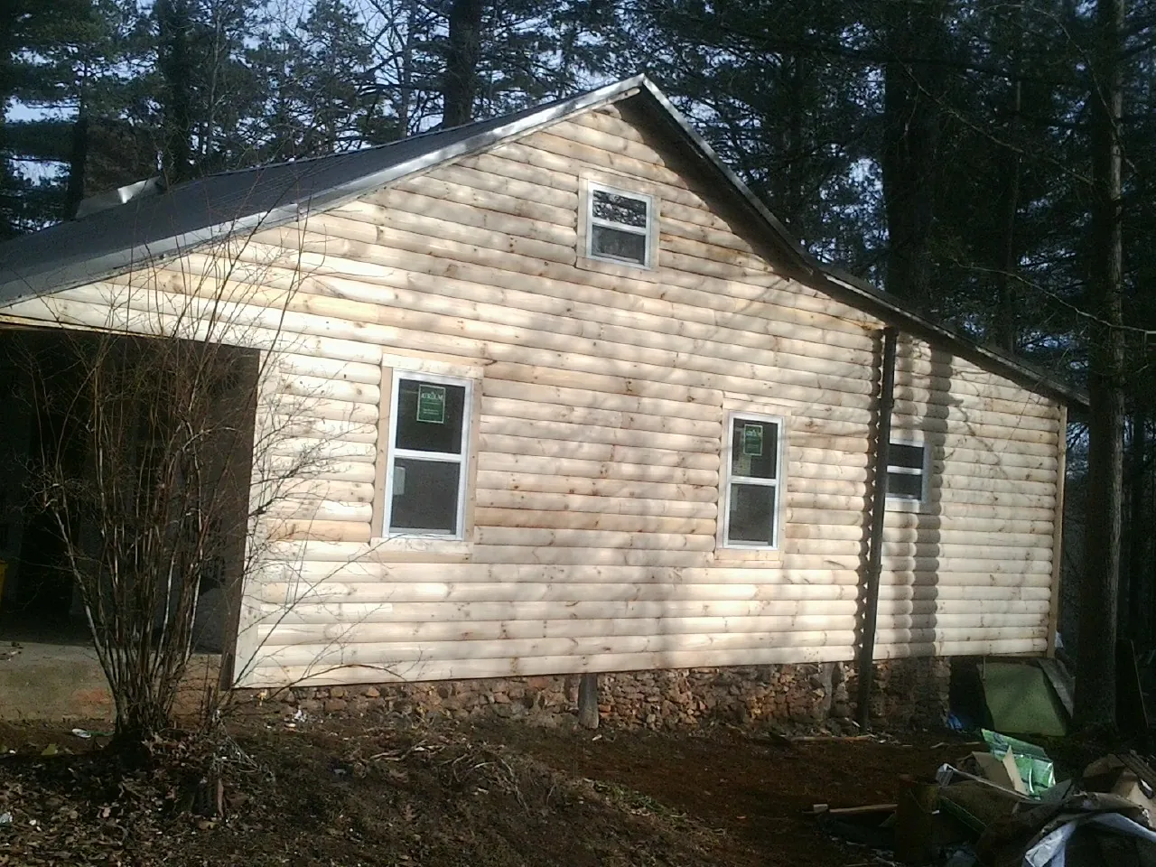 New log siding and dark metal roofing on a gable end in Zephyrhills